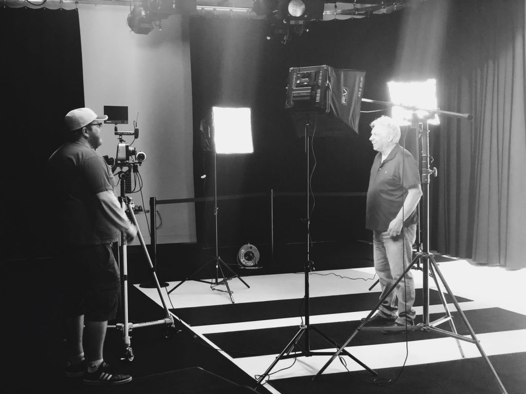 Image of 2 men in the Ignite Studio, surrounded by lights and cameras