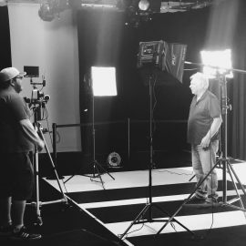 Image of 2 men in the Ignite Studio, surrounded by lights and cameras
